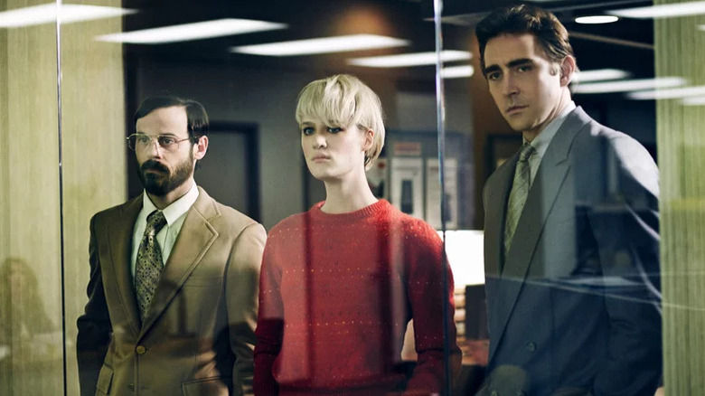 Scoot McNairy as Gordon, Mackenzie Davis as Cameron, and Lee Pace as Joe standing behind office glass in Halt and Catch Fire