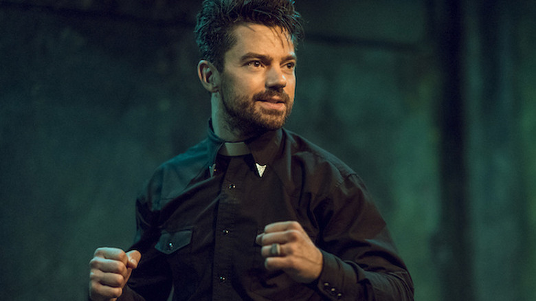 Dominic Cooper as Jesse with his fists up in a black suit in Preacher