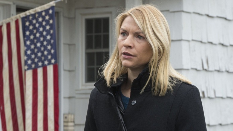 Carrie Mathison) stands outside a house with an American flag in Homeland