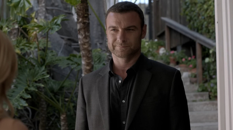 Ray Donovan (Liev Schreiber) stands smiling at a woman outside in Ray Donovan