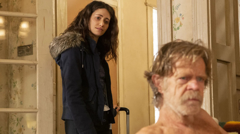 Fiona Gallagher (Emmy Rossum) looks thoughtfully at a seated and disheveled Frank Gallagher (William H. Macy) in Shameless