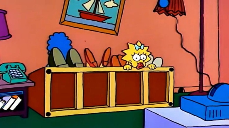 Maggie peeks over the couch as the rest of the Simpsons have fallen over in this couch gag