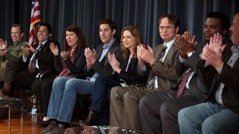 The employees of Dunder Mifflin clip on a stage on The Office.