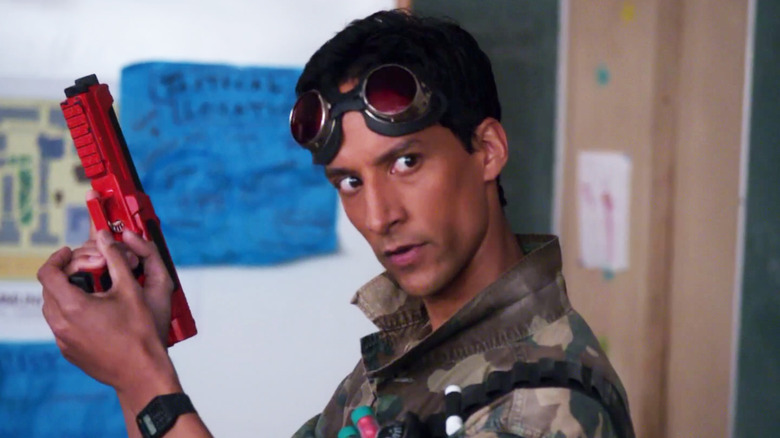 Danny Pudi as Abed Nadir, reloading a paintball gun on Community.