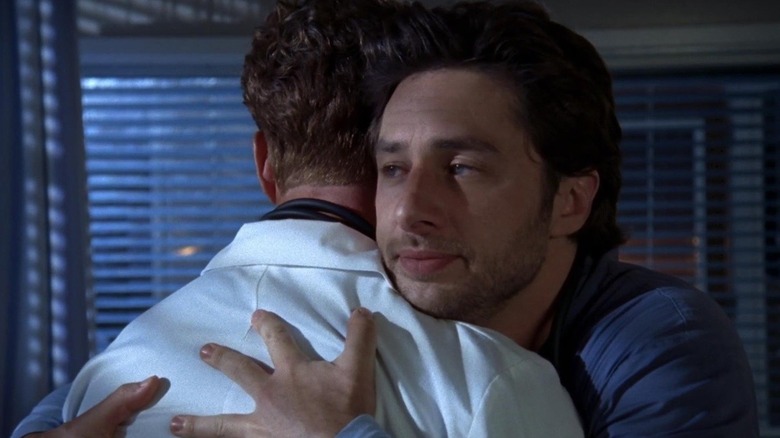 John C. McGinley as Perry Cox and Zach Braff as J.D., hugging each other in a hospital room on Scrubs.