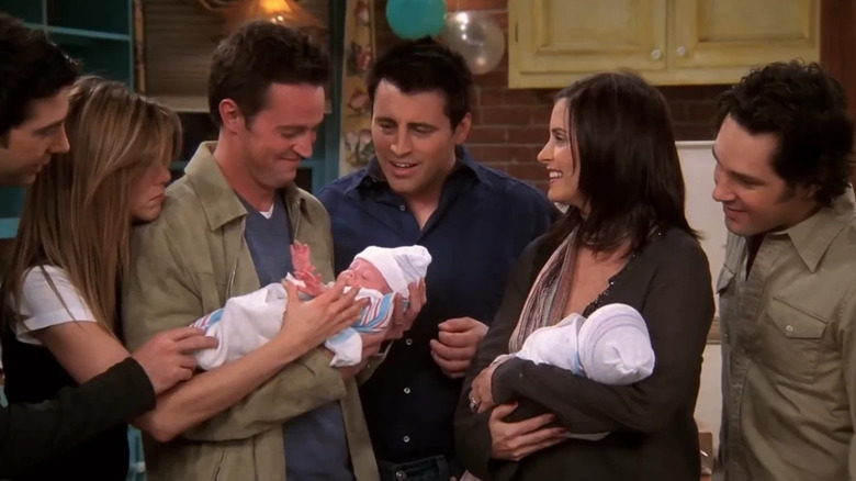 The Friends ensemble surround Chandler and Monica's children on Friends.