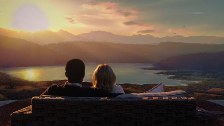 William Jackson Harper as Chidi Anagonye and Kristen Bell as Eleanor Shellstrop, sitting together on a couch overlooking a sunset on The Good Place.