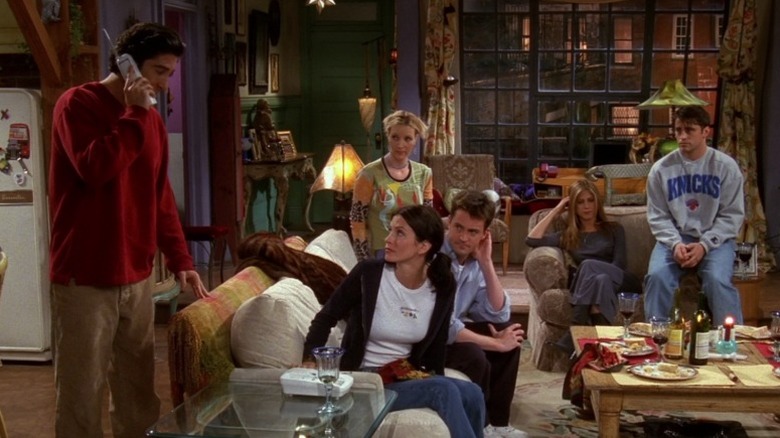 Ross Geller talking on the phone while everyone else watches him on Friends S5E6
