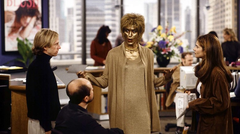 Dennis Finch and Maya Gallo stare at Nina Van Horn, who is painted gold in Just Shoot Me!