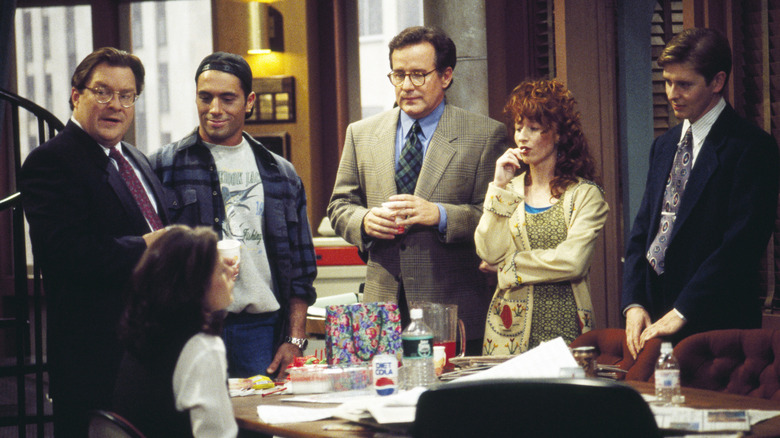 The NewsRadio crew gathered around a desk