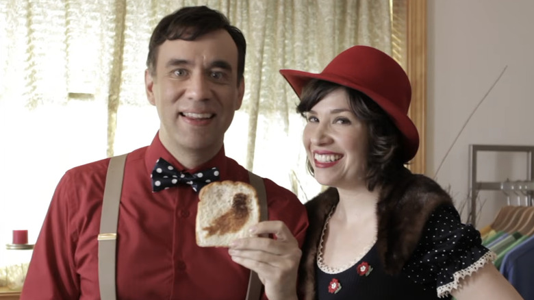 Fred Armisen and Carrie Brownstein as Bryce and Lisa holding up a piece of toast with a bird on it in Portlandia
