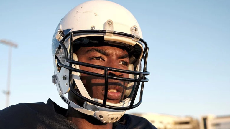 Spencer James (Daniel Ezra) wears his football gear in a field on All-American