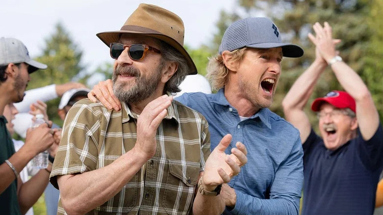 Pryce Cahill (Owen Wilson) happily shouts holding an applauding Mitts (Marc Maron) around fans on Stick