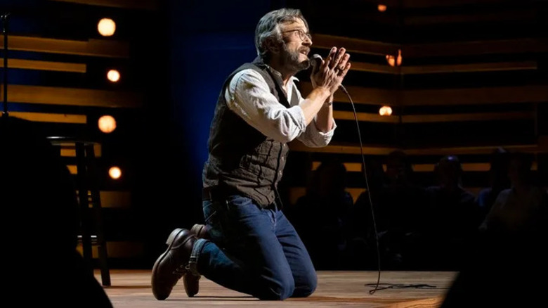 Marc Maron gets on his knees in mock prayer in Marc Maron: End Times Fun (2020)