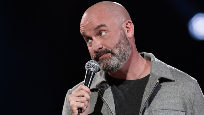 Tom Segura looks expectantly while holding a microphone in Tom Segura: Sledgehammer (2023)