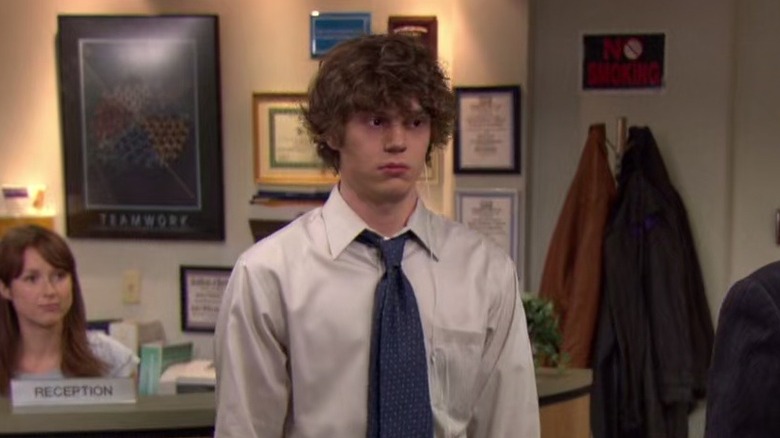 Evan Peters as Luke, standing in front of Erin in "The Office."