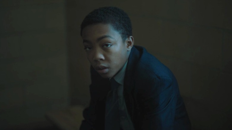 Kevin sitting (Asante Blackk) on a bench and looking up on When They See Us S1E2