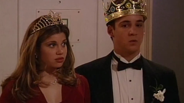Topanga in dress wearing crown next to Cory in tux and crown, both looking serious