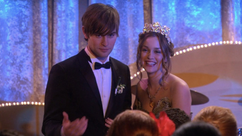 Nate in tux standing next to Blair in dress and crown