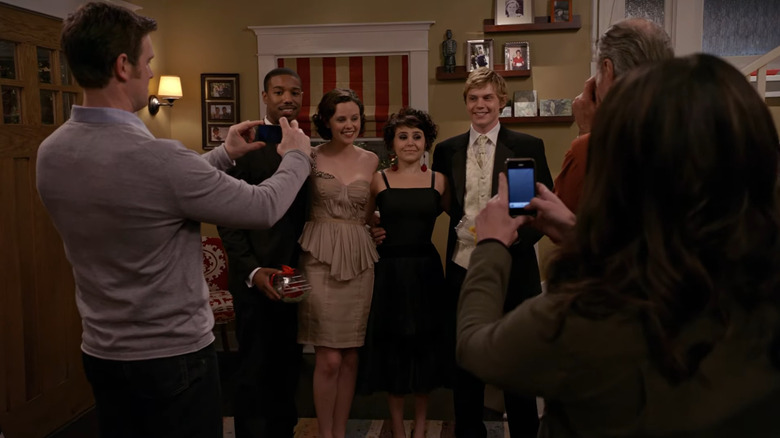 Alex, Haddie, Amber, and Brandon posing for prom photos in front of parents