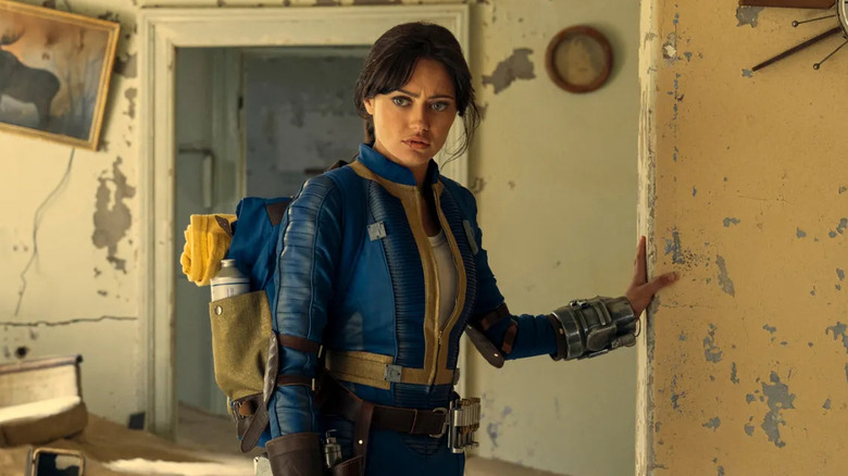 Ella Purnell as Lucy, walking through an abandoned house in Fallout.