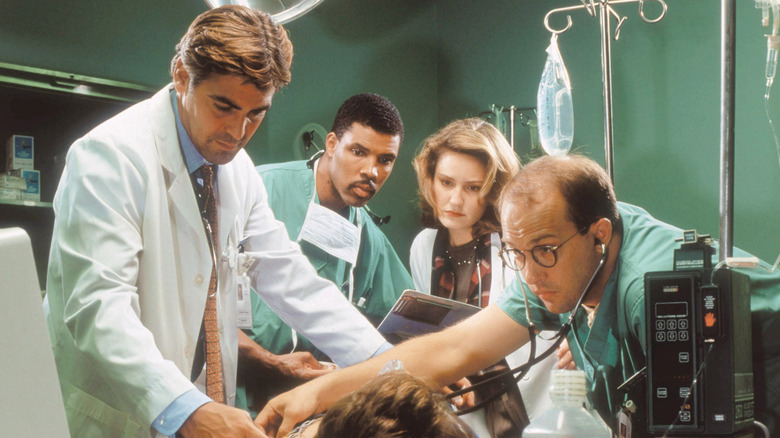 Doug Ross, Peter Benton, Susan Lewis and Mark Greene work on a patient in ER