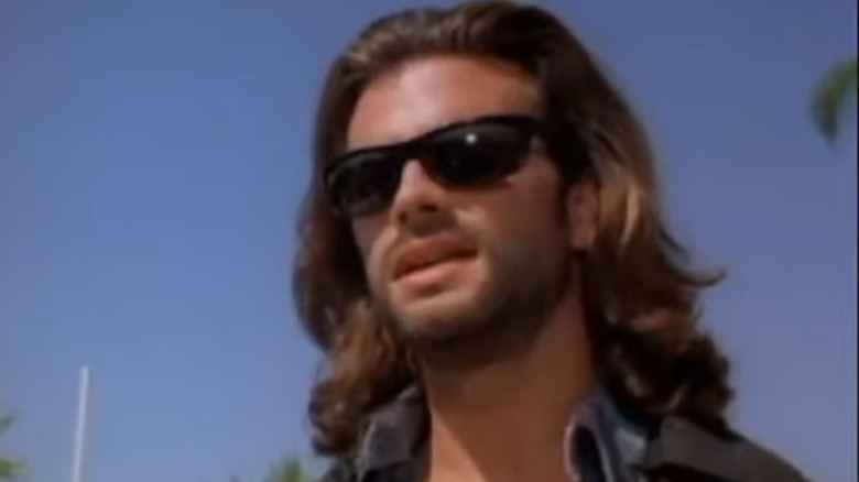 Lorenzo Lamas as Reno Raines talking with sunglasses on in Renegade