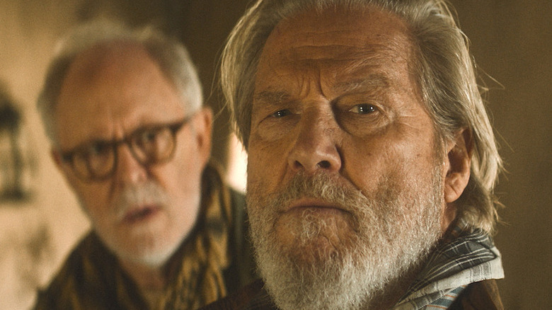 Jeff Bridges as Dan Chase looking towards the camera with John Lithgow as Harold Harper behind him and out of focus in The Old Man