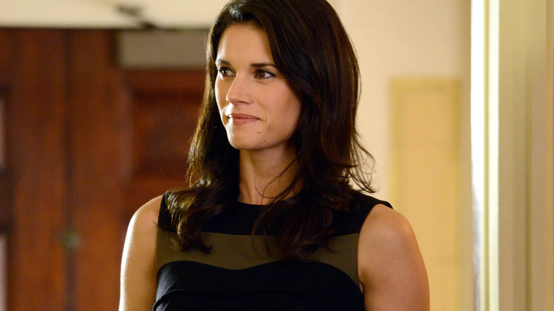 Andy McNally (Missy Peregrym) stands smiling while wearing a formal dress in Rookie Blue