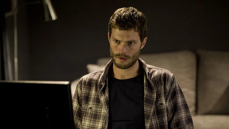 Jamie Dornan as Peter Paul Spector, looking at a computer in The Fall.