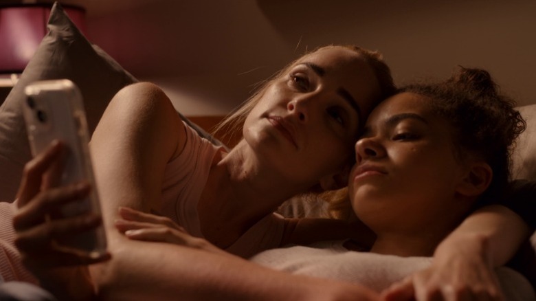 Georgia hugging Ginny in bed while Ginny looks at her phone on Ginny & Georgia S3E5