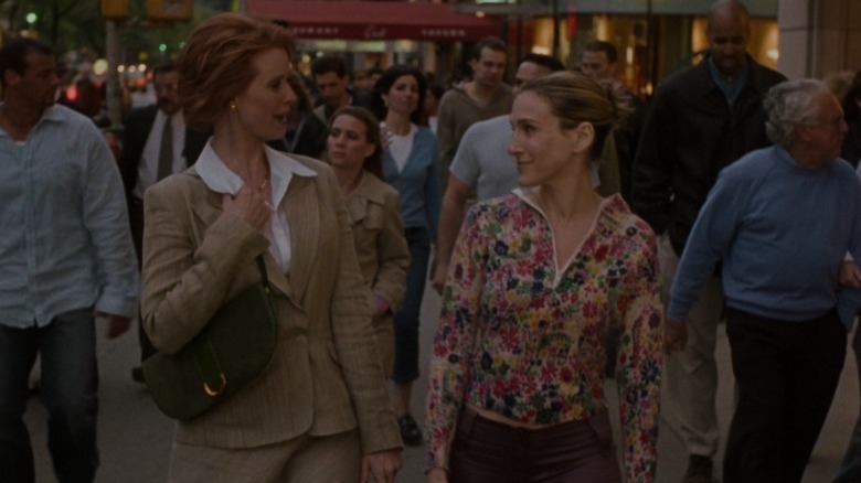 Miranda and Carrie smiling at each other while walking down the street on Sex and the City S6E4