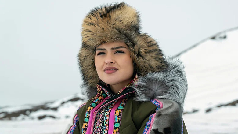 Anna Lambe as Siaja in fur-lined hat and jacket in snowy landscape in North of North