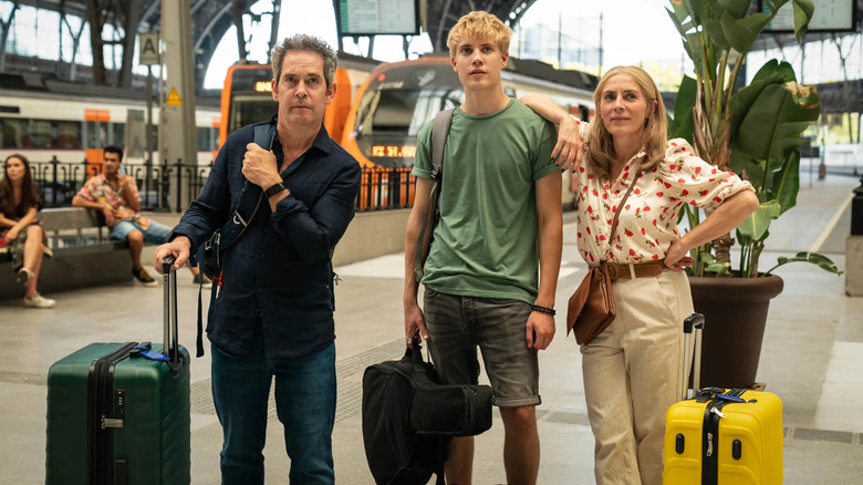 family glancing up holding luggage in Us