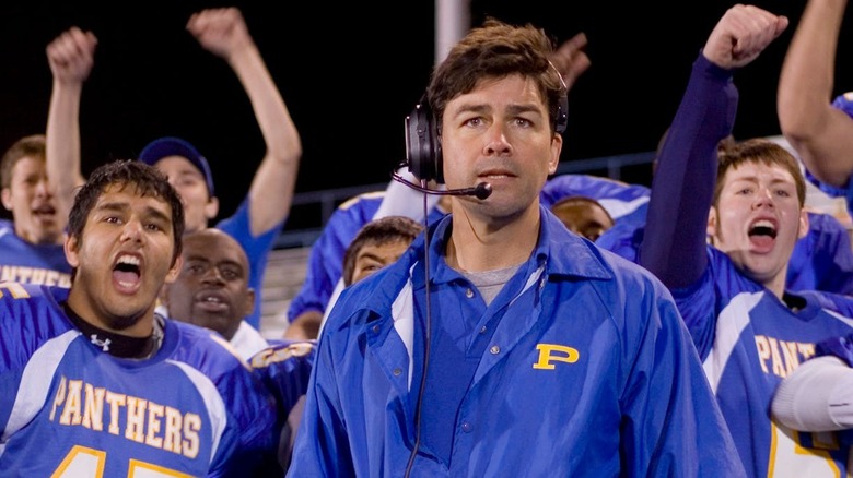 Kyle Chandler as Eric Taylor stands with his football team in Friday Night Lights