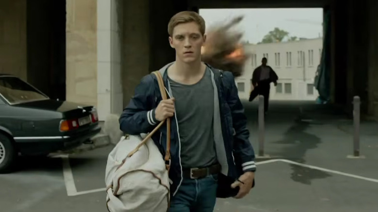Jonas Nay's Martin Rauch walking away from an explosion on Deutschland 83