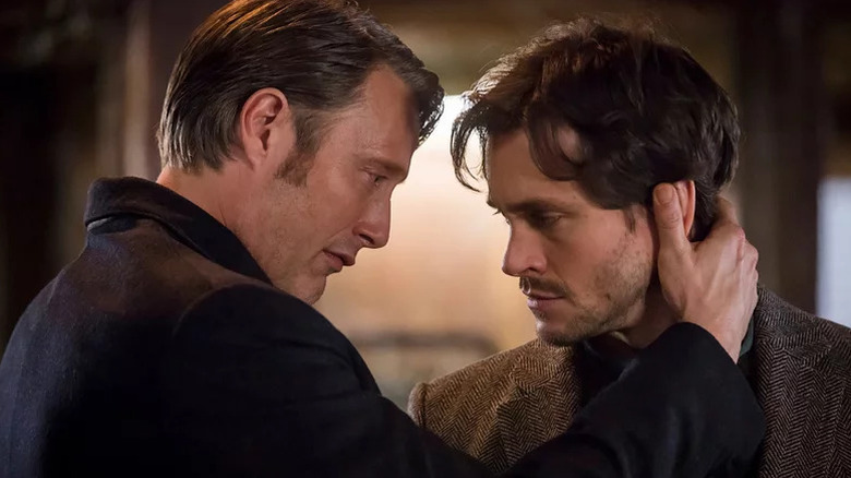 Mads Mikkelsen as Hannibal grabbing the back of Hugh Dancy as Will Graham's head in Hannibal