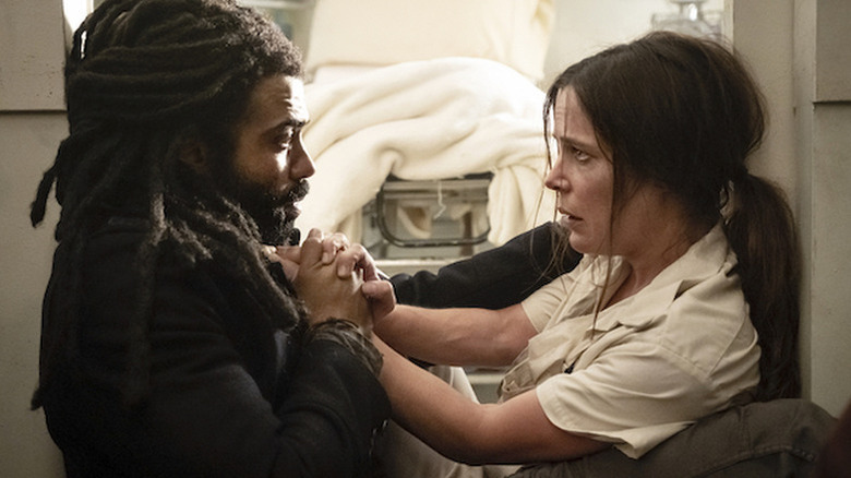 Andre (Daveed Diggs) and Josie (Katie McGuinness) holding hands on "Snowpiercer."