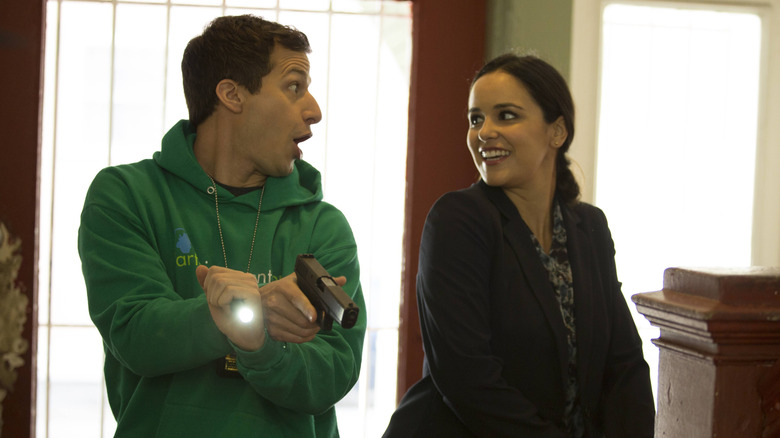 Jake and Amy smiling at each other holding guns in Brooklyn Nine-Nine