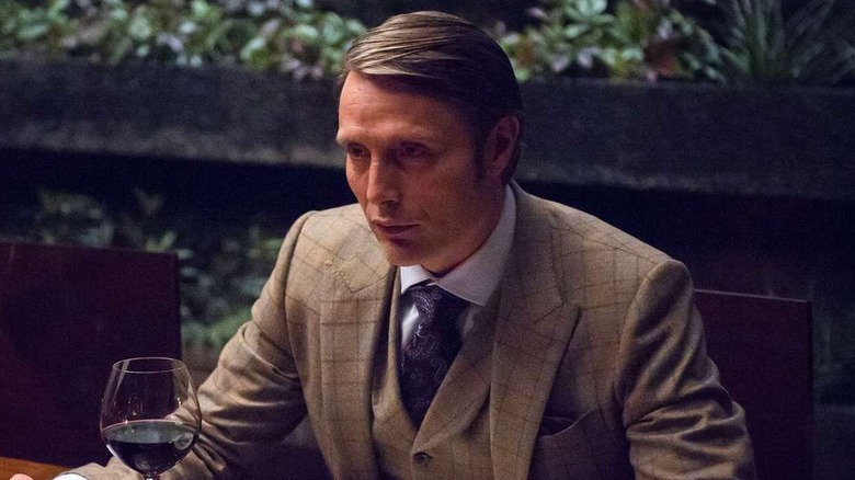 Mads Mikkelson as Hannibal Lecter at a dinner table in Hannibal