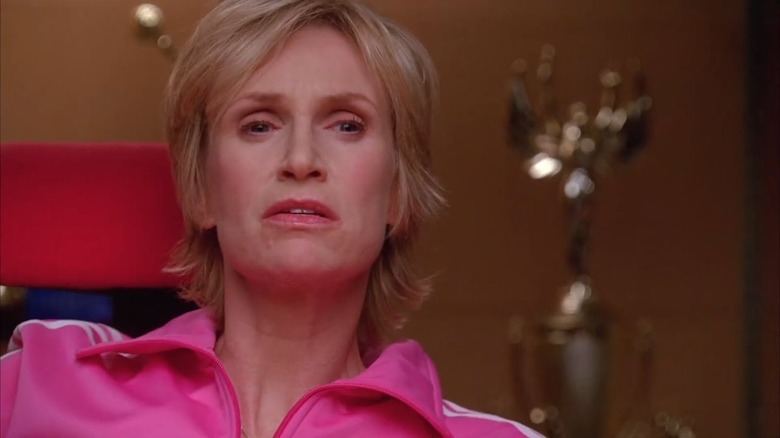 Jane Lynch as Sue Sylvester in a pink tracksuit in Glee