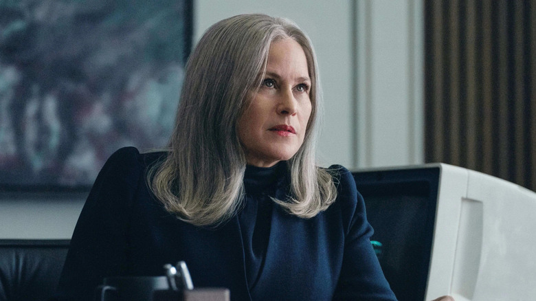 Patricia Arquette as Harmony Cobel, sitting at her desk in Severance.