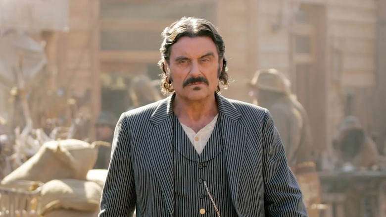 Ian McShane as Al Swearengen walks down the street in Deadwood