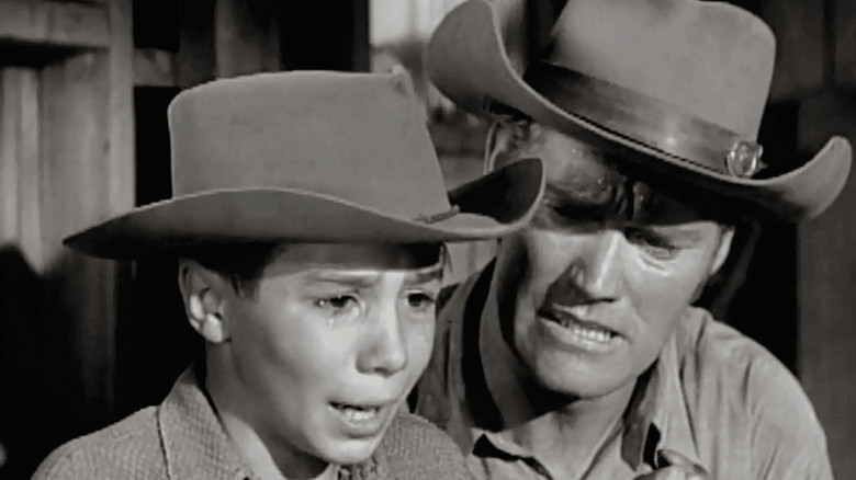 Johnny Crawford as Mark McCain cries next to Chuck Connors as Lucas McCain in The Rifleman