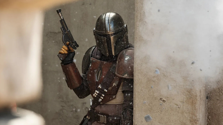 Din Djarin takes cover during a fight in The Mandalorian