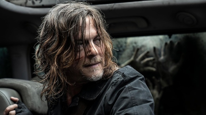 A disheveled Daryl Dixon (Norman Reedus) looks around in a car in The Walking Dead: Daryl Dixon
