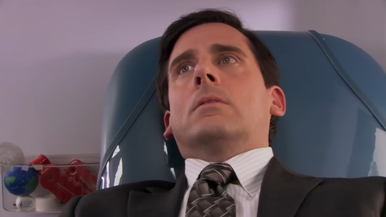Steve Carell as Michael Scott sits in a chair on The Office