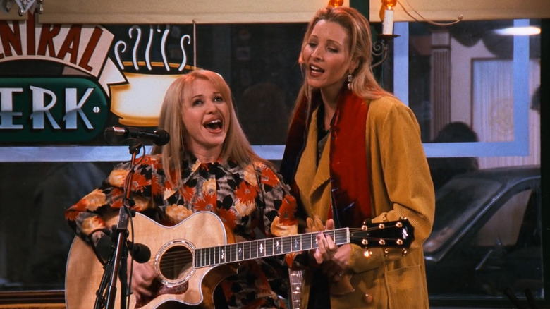 E.G. Daily as Leslie sitting and playing guitar while singing in Central Perk with Lisa Kudrow as Phoebe Buffay in Friends