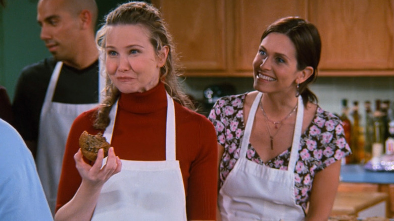 Molly Hagan as the cooking teacher trying Joey's cookie while Courteney Cox as Monica Geller stands behind her wearing an apron in Friends