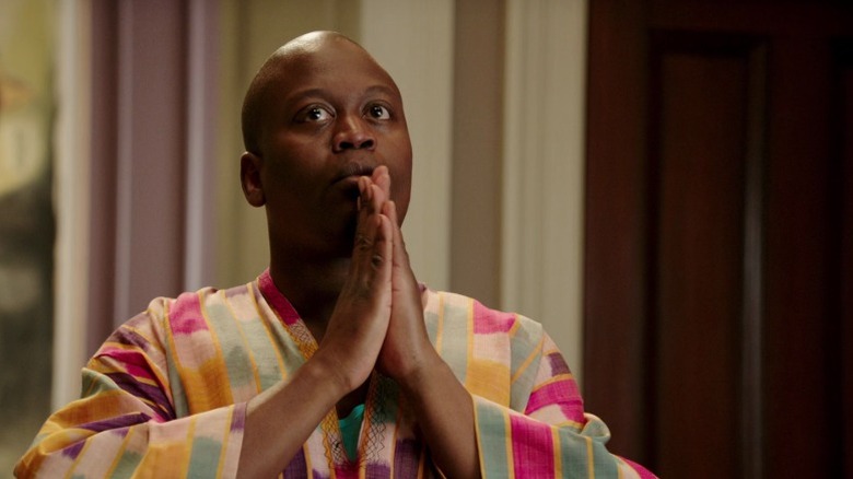 Titus clasping his hands together and looking up on Unbreakable Kimmy Schmidt S1E6